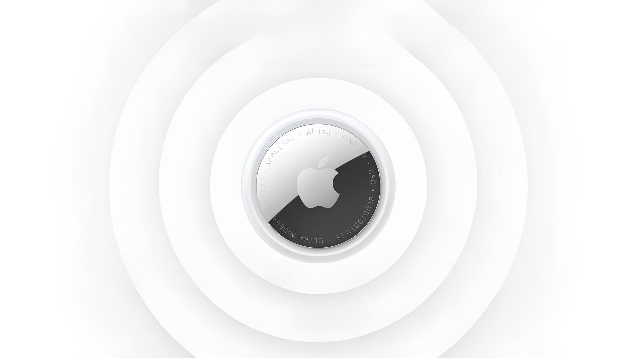 Apple AirTag tracker centered on a white background with concentric circular design, showing the Apple logo and stainless steel battery cover.